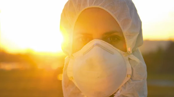 PORTRAIT: Doctora con mascarilla y traje fuera al atardecer —  Fotos de Stock