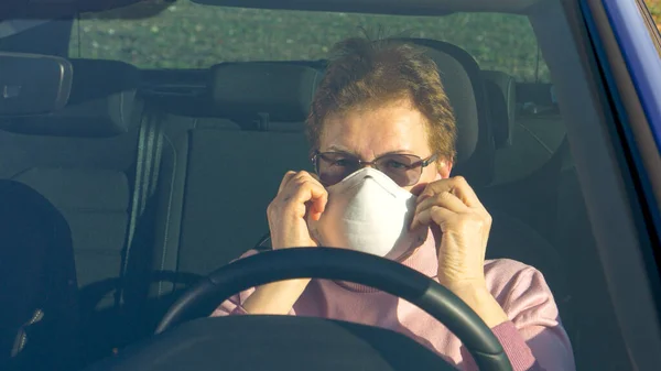 CERRAR: Mujer mayor se pone una mascarilla antes de salir de su coche. —  Fotos de Stock