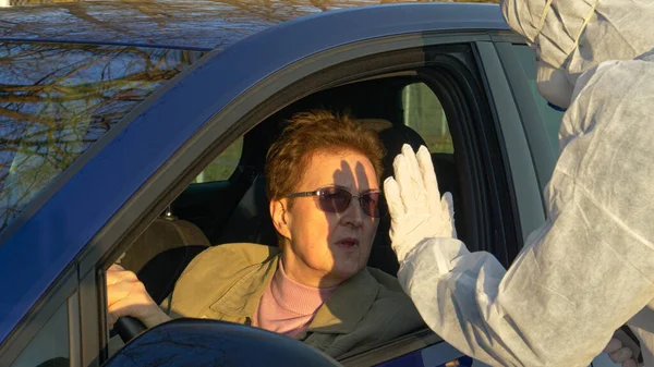 CLOSE UP: Nurse forbids elderly woman to enter the city during covid 19 pandemic — Stock Photo, Image