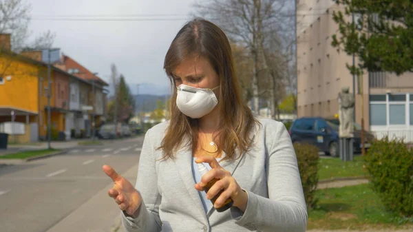 CERRAR: La joven mujer de negocios caucásica que lleva una mascarilla facial se limpia las manos. —  Fotos de Stock