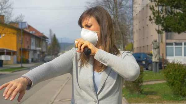 PORTRAIT: Stressed Caucasian businesswoman sprays herself with hand-sanitizer. — Stock Photo, Image