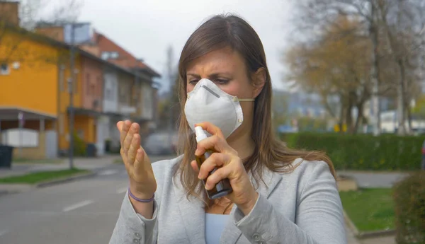 CERRAR: Chica desinfecta sus manos con spray desinfectante antes de ir a trabajar —  Fotos de Stock