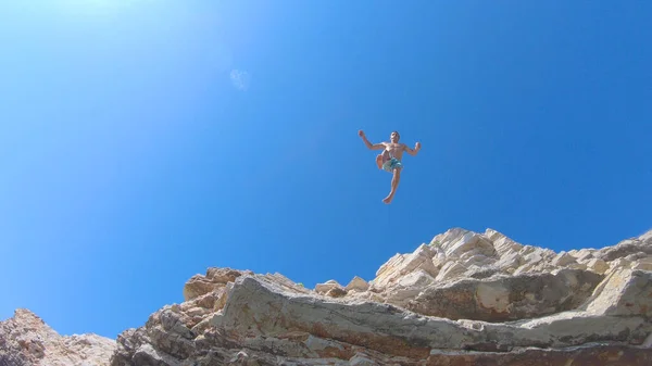 BOTTOM UP: Spännande turist på semester dyker från en klippa och ner i havet. — Stockfoto