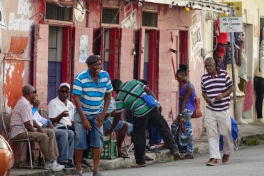 Yerel halk, eski mağazanın önünde oturan arkadaşlarıyla konuştuktan sonra güler.