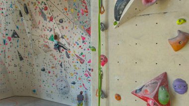 Rekabetçi kaya tırmanışı trenleri içeride, koçu onu bağlıyor..