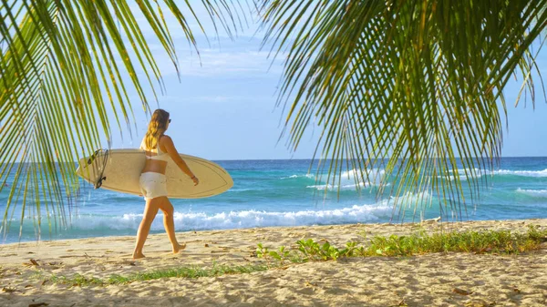 Fit ragazza surfista caucasica passeggiate lungo la pittoresca spiaggia tropicale nei Caraibi — Foto Stock