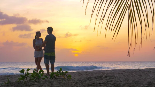 LOW ANGLE: Carefree young tourist couple dances on white sand beach at sunset — Stockfoto