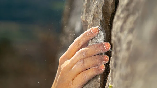 MACRO: Polvere di magnesio bianco vola nell'aria mentre scalatore scala una scogliera. — Foto Stock