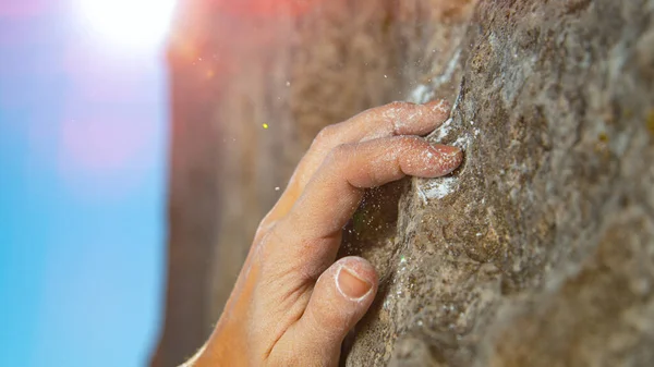 MACRO, LENS FLARE:挑戦的な崖を拡大しながら女性はクリンプホールドをつかむ. — ストック写真