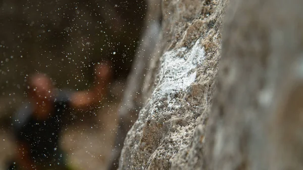 MACRO: Partículas de magnésio voam ao redor de um crimpete depois que o alpinista desliza e cai — Fotografia de Stock