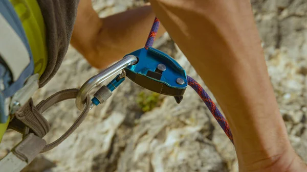 Sluiten: Belayer trekt aan het veiligheidstouw dat door een GriGri-systeem loopt. — Stockfoto