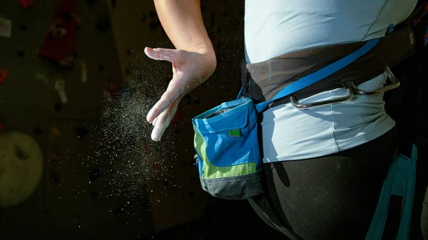 FERMER : Une jeune grimpeuse se tape les doigts pour enlever l'excès de magnésium. — Photo