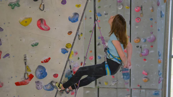 CERRAR: Jovencita escalando en el interior de tiza antes de continuar su ascenso. — Foto de Stock