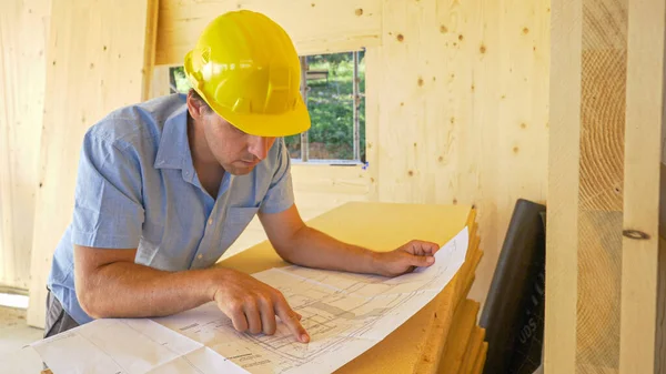 CHIUSURA: Focused contractor analizza le planimetrie di una moderna casa CLT. — Foto Stock