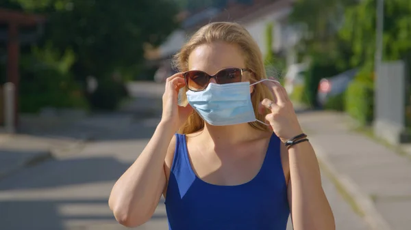 PORTRAIT: Mujer responsable con gafas de sol se pone su mascarilla protectora. —  Fotos de Stock