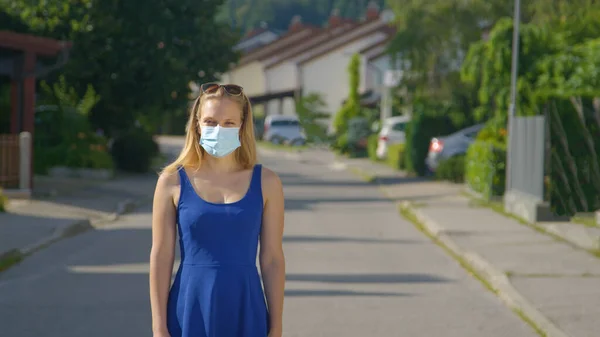 PORTRAIT: Joven mujer caucásica lleva una mascarilla protectora durante su paseo. —  Fotos de Stock