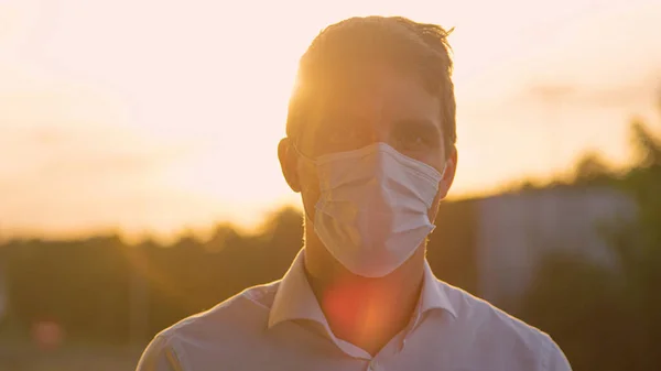 PORTRAIT Joven sonríe bajo su máscara protectora durante la pandemia de covid-19 — Foto de Stock