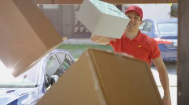 Teslimatçı, güneşli bir günde birinin garaj yoluna paket atar..