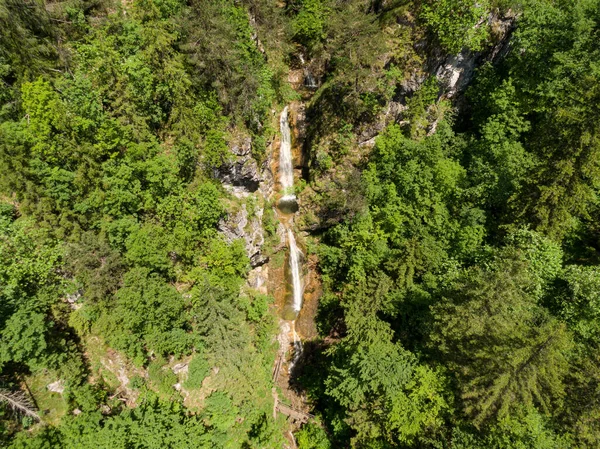 АЭРИАЛ: кинематографический вид на великолепный каскадный водопад в зеленой долине Логар. — стоковое фото
