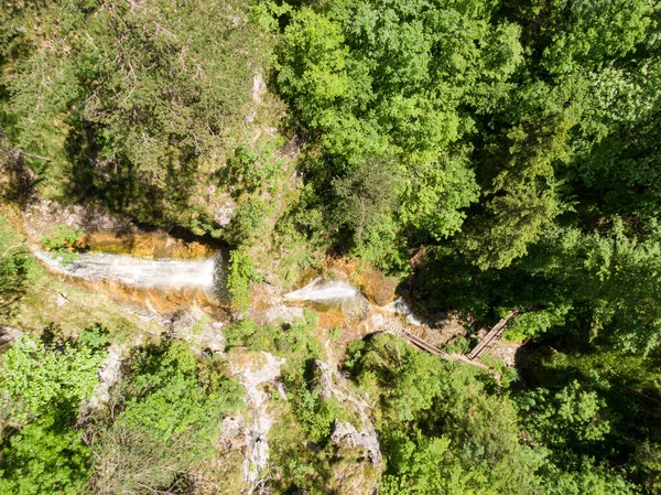 AERIAL: Piscinas naturales de agua cristalina se reúnen bajo un impresionante curso de agua. — Foto de Stock