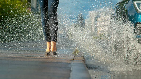 CLOSE UP: Unrecognizable woman wearing high heels gets splashed with water.