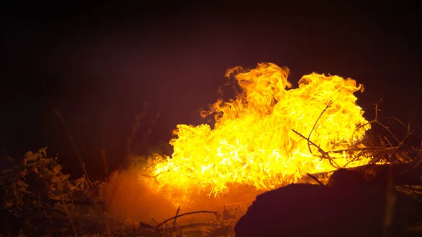 CLOSE UP: Fire burning in the of the night gets splashed with waste kerosene. — 图库照片