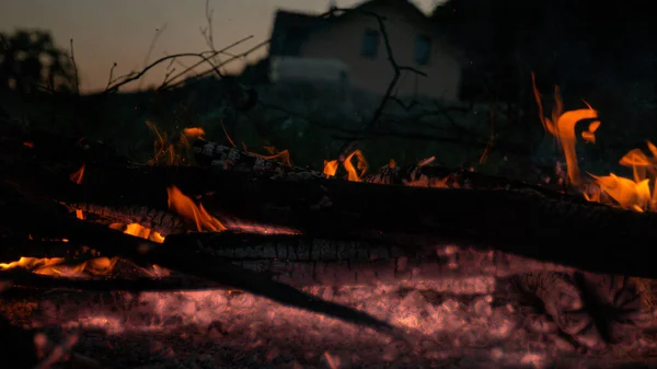 ZAMKNIJ SIĘ: Żar wciąż świeci i delikatnie pali się na podwórku czyjegoś domu. — Zdjęcie stockowe