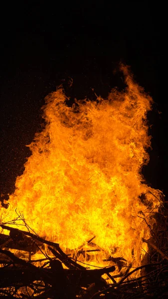 VERTICAL: Tiro detalhado de chamas quentes ardentes engolindo uma grande pilha de lenha. — Fotografia de Stock