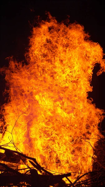 VERTIKEL: Lagerfeuer brennt durch trockenes Brennholz, das sauber im Kamin gestapelt ist. — Stockfoto