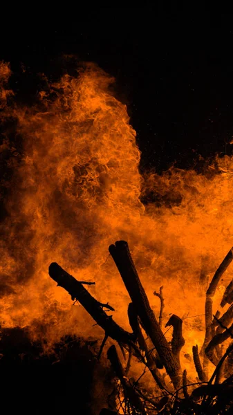 VERTIKEL: Großes Lagerfeuer brennt durch ordentlich im Kamin gestapeltes Brennholz. — Stockfoto