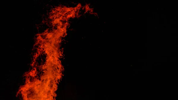 CLOSE UP: A large blaze bursts high into the dark night sky near a campfire. — Stock Photo, Image