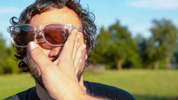 CLOSE UP: Чоловічі сонцезахисні окуляри вилітають з обличчя після того, як невідомий врізається в обличчя . — стокове фото