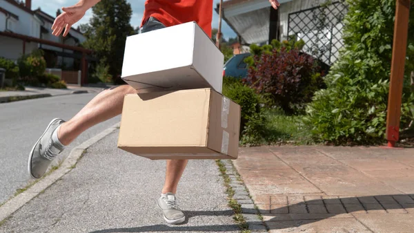CLOSE UP: Unrecognizable delivery guy drop kicks package into someone's driveway — Stock Photo, Image