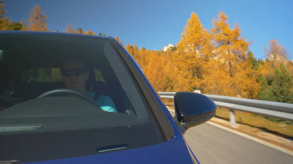 CERRAR: Joven turista masculino conduce su coche azul a lo largo de un pintoresco camino de montaña — Foto de Stock