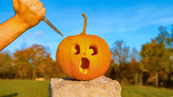 CLOS E UP: Calabaza de Halloween con una cara impactada está a punto de ser apuñalado —  Fotos de Stock