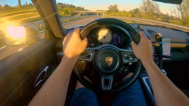 POV: Slovenya kırsalında boş bir asfalt yolda yeni bir Porsche sürmek.