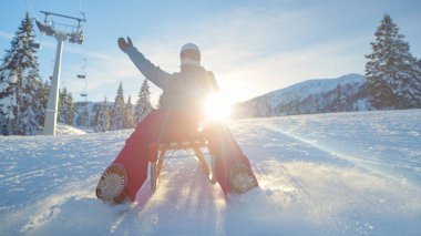 Gülümseyen beyaz kadın kapalı bir kayak merkezinin yamaçlarından aşağı kayıyor..