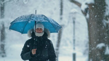 COPY SPACE, PORTRAIT: Woman explores the idyllic white park during a snowstorm. clipart