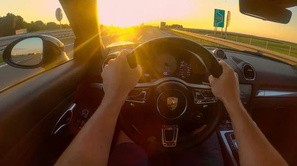 POV: Los rayos de sol dorados de la noche brillan dentro de la cabina mientras conduce un Porsche — Foto de Stock