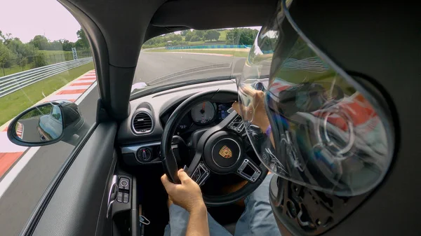 Adam güçlü Porsche spor arabasıyla boş asfalt yarış pistinde yarışıyor.. — Stok fotoğraf