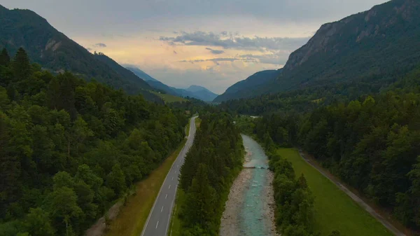 DRONE: Flying above a scenic road leading towards the town of Kranjska Gora. — Stock Photo, Image