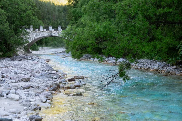Prachtige turquoise gekleurde bergbeekjes onder een oude stenen brug. — Stockfoto