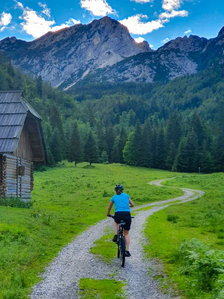 垂直：难以辨认的女人骑着山地自行车沿着风景秀丽的远足小径 — 图库照片