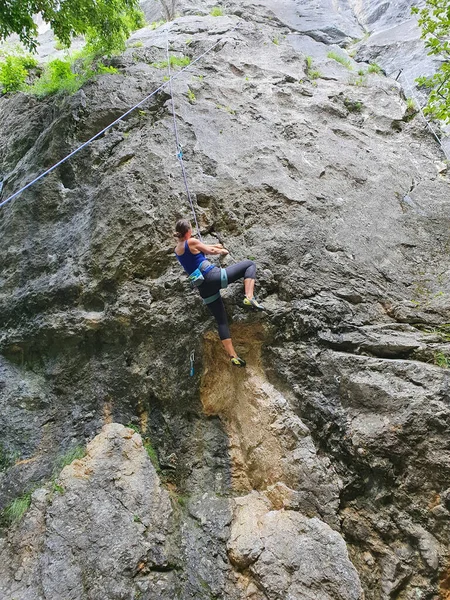 VERTICAL: Mulher sem medo experiente alpinista ascende uma parede desafiadora. — Fotografia de Stock