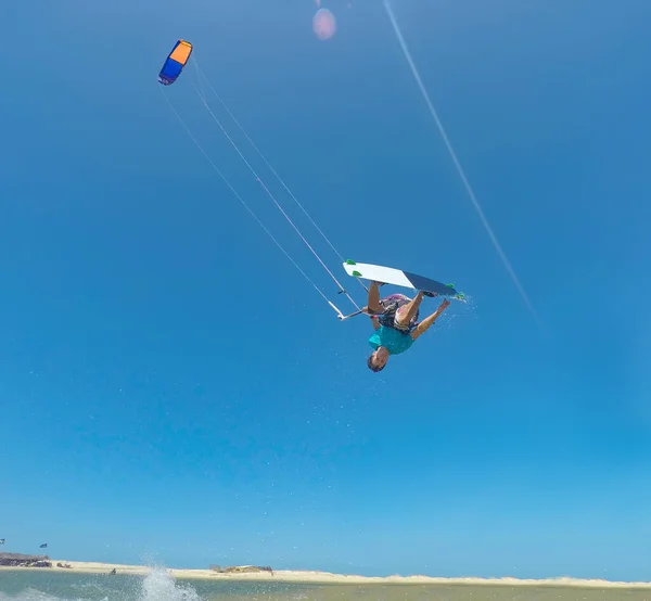 LENS FLARE: Sportowy kitesurfer robi zapierającą dech w piersiach akrobatyczną sztuczkę w słoneczny dzień — Zdjęcie stockowe