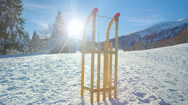 LENS FLARE：木制雪橇笔直地站在白雪覆盖的草地中间. — 图库照片