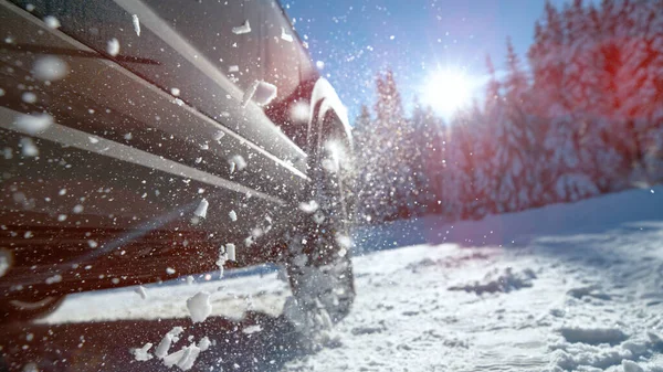 Kar parçaları, araba tekerleklerinden havada uçarken gün ışığında parlıyor. — Stok fotoğraf