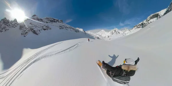 SELFIE Młoda turystka strzępy śniegu puder podczas heliboardingu w skałach — Zdjęcie stockowe
