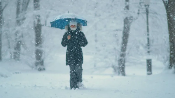 在一个下着雪的圣诞节，年轻的白人女性正在探索田园诗般的公园. — 图库照片