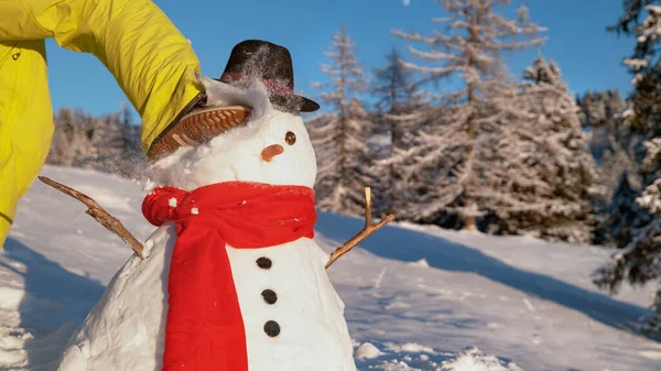 閉じる:認識できない人は、晴れた冬の日に建てられた雪だるまを蹴ります. — ストック写真